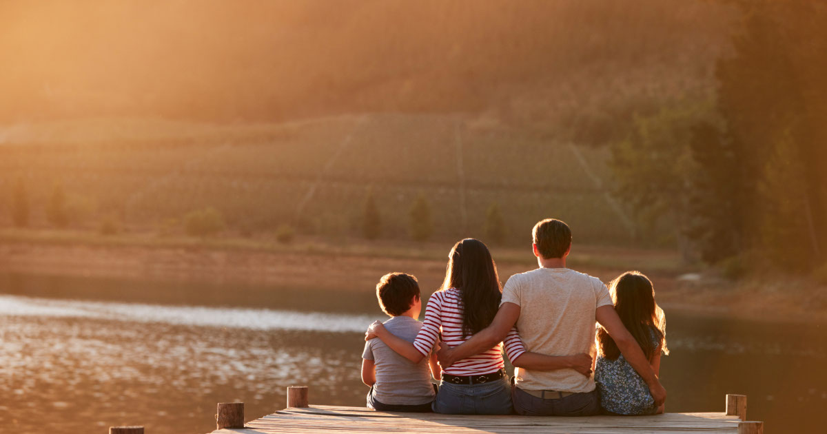 Family enjoying a lakeside vacation at Deep Creek Lake with dock and mountain views