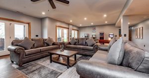 Open-concept vacation rental living space with multiple gathering areas and outdoor deck access