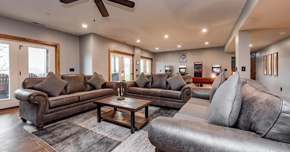 Open-concept vacation rental living space with multiple gathering areas and outdoor deck access