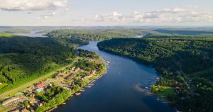 Aerial view of Deep Creek Lake, Maryland, on a sunny summer day with boats on the water and wooded shoreline