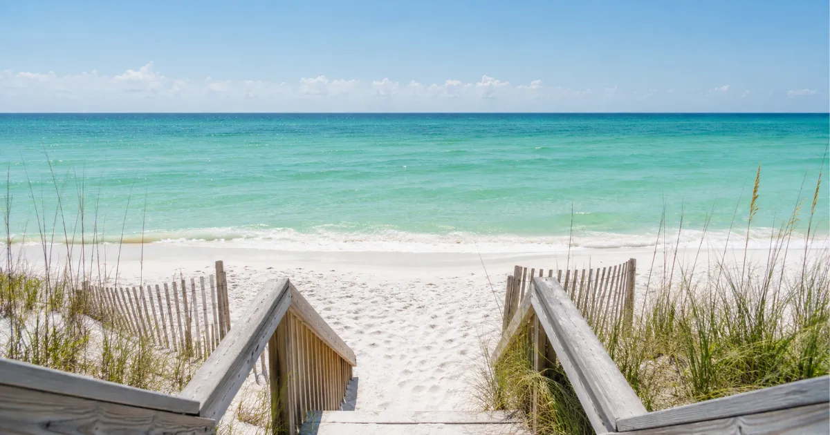 Calm emerald Gulf water and white sand at a public beach access in Panama City Beach