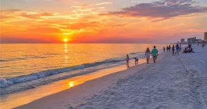 Sunset over the Gulf at Panama City Beach with families on the shore