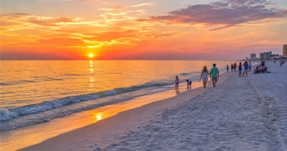 Sunset over the Gulf at Panama City Beach with families on the shore