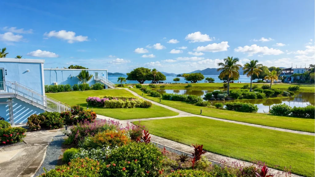 Landscaped resort lawns, walking paths and ponds leading toward the beach and Caribbean Sea.