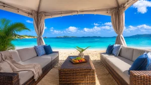 Shaded beach cabana furnished with wicker sofas, blue pillows, and a central table overlooking the bright turquoise waters of Sapphire Bay.