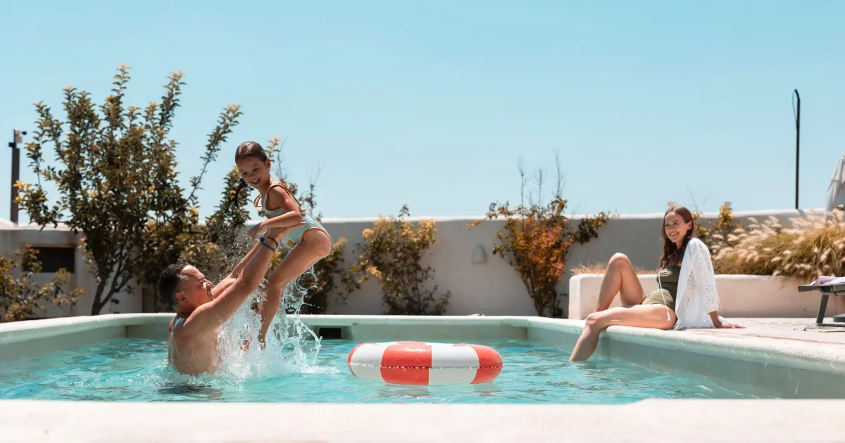 Large family group gathered around an outdoor pool and patio at a Swack Vacations rental home