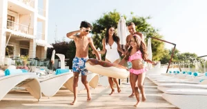 Children playing in a resort kiddie pool with sprayers on a sunny afternoon
