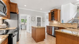 blue-bayou-kitchen-3 | Swack Vacations Spacious kitchen with stainless appliances, granite countertops, and warm wood cabinets.