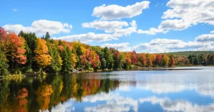 Quiet Deep Creek Lake shoreline with autumn trees reflected in calm water