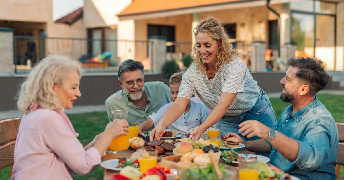 Group of friends and family sharing a meal on a vacation rental deck