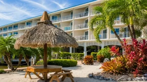 pointe-1207-seating | Swack Vacations Beachside resort building with white balconies, surrounded by palm trees and a thatched palapa.