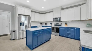 whipering-winds-slider-images 32 | Swack Vacations Bright, modern kitchen with white upper cabinets, blue lower cabinets, marble countertops, and stainless steel appliances.